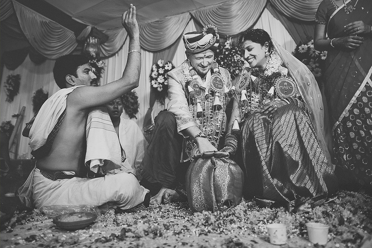 at a Hindu wedding ceremony photographed by destination wedding photographer Europe Bride and groom wearing flower garlands