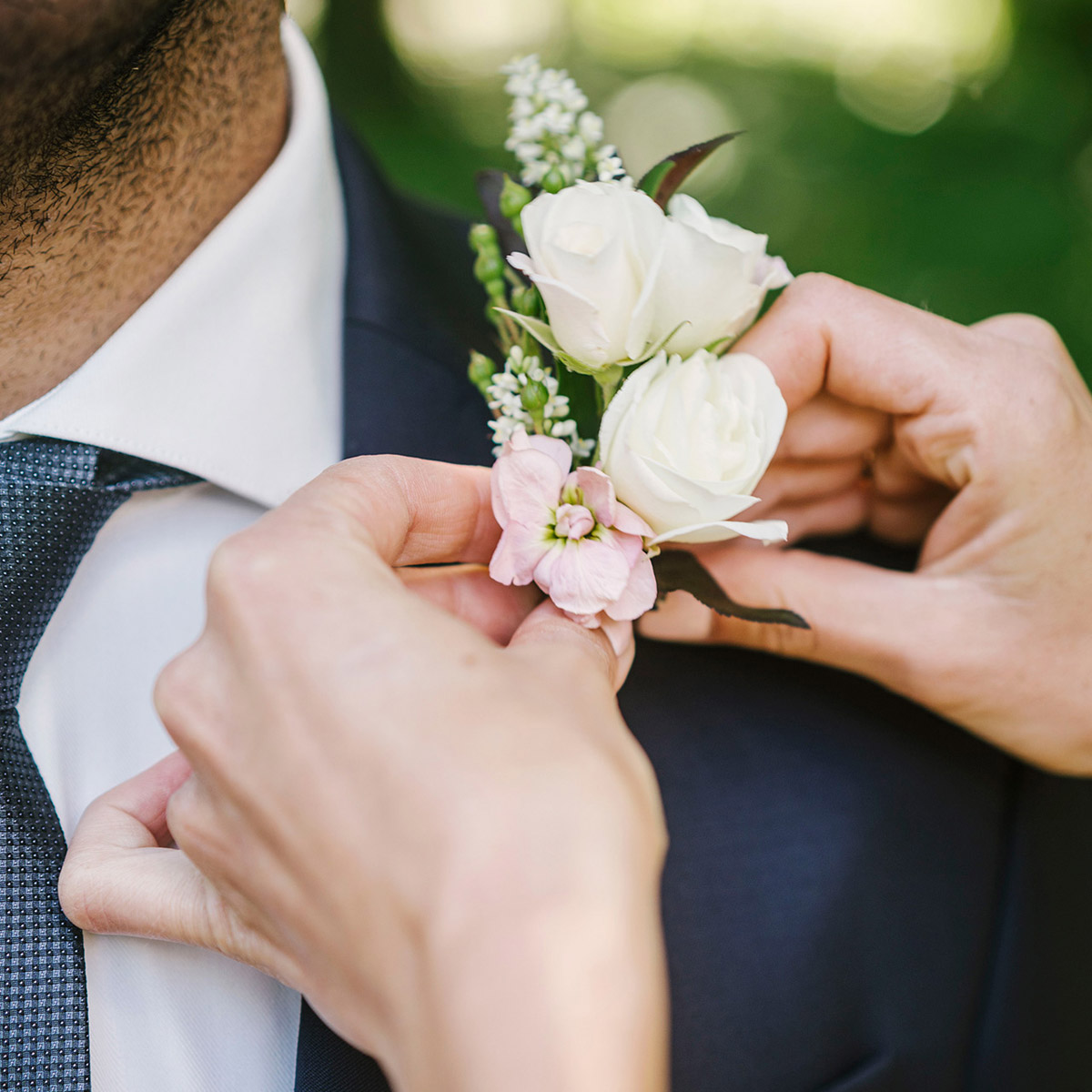 Hochzeitsblumen: Die Braut befestigt den Anstecker für den Bräutigam mit crémefarbenen Rosen. DER HOCHZEITSFOTOGRAF AUS BERLIN ZEIGT DIESE HOCHZEITSREPORTAGE IM BLOG. © www.hochzeitslicht.de #hochzeitslicht