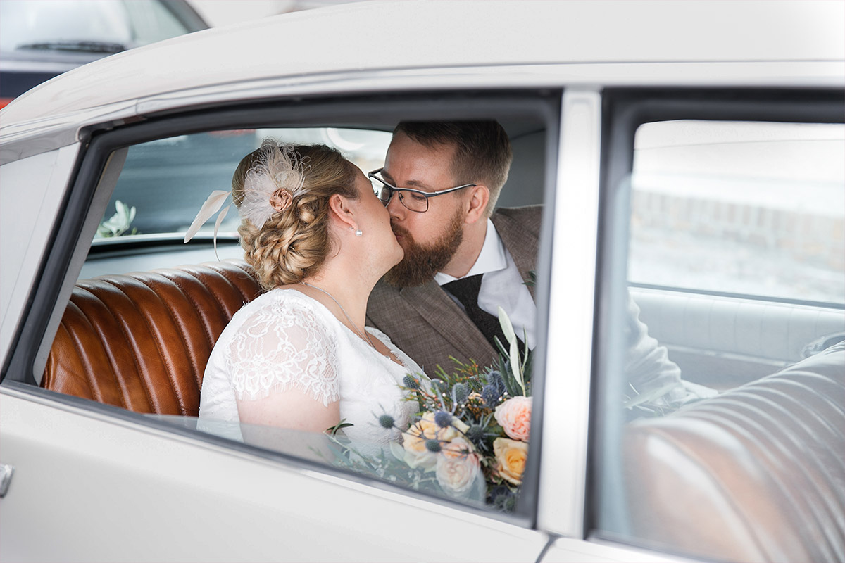 Hochzeitsfoto von Brautpaar in Hochzeitsauto aufgenommen von Hochzeitsfotograf bei Scheunenhochzeit in Brandenburg, Lausitz © Hochzeitsfotograf Berlin www.hochzeitslicht.de