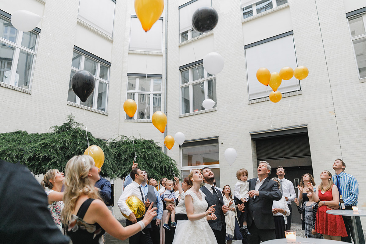 Hochzeitsfotografie von Hochzeitsgesellschaft beim Steigenlassen von Ballons im Innenhof der Kunztschule - Kunztschule Berlin-Mitte Hochzeitsfotograf © www.hochzeitslicht.de