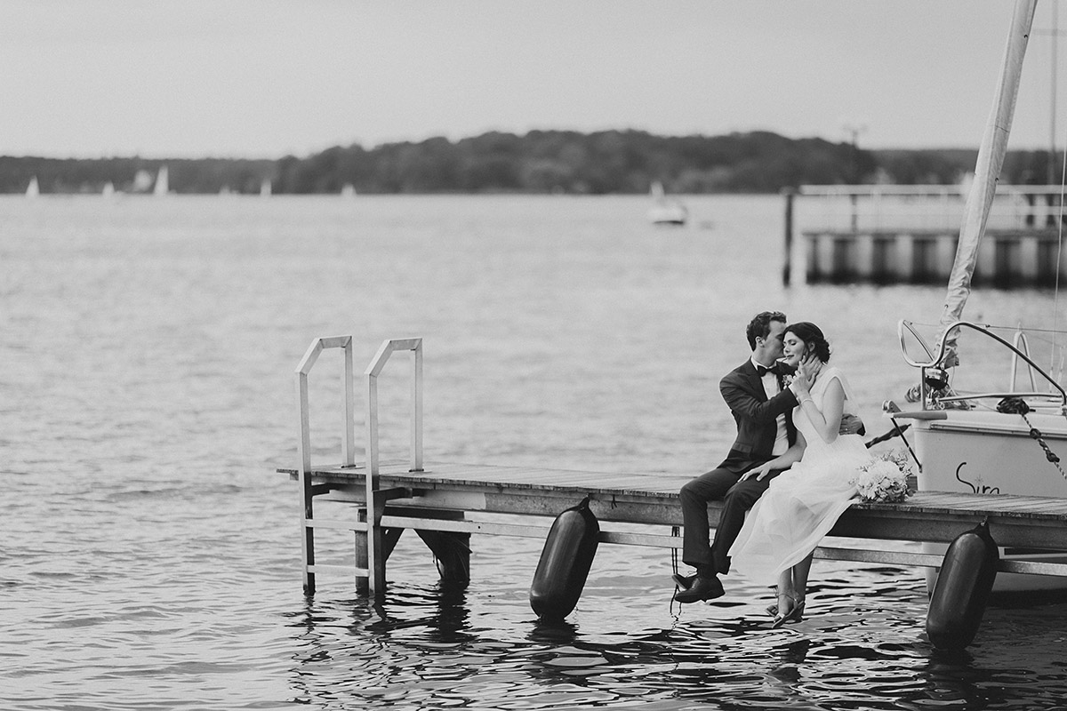 romantische schwarz-weiß Hochzeitsfotografie von Brautpaar auf Bootssteg am Wannsee - Gästehaus Villa Blumenfisch am Großen Wannsee Berlin Hochzeitsfotograf © www.hochzeitslicht.de