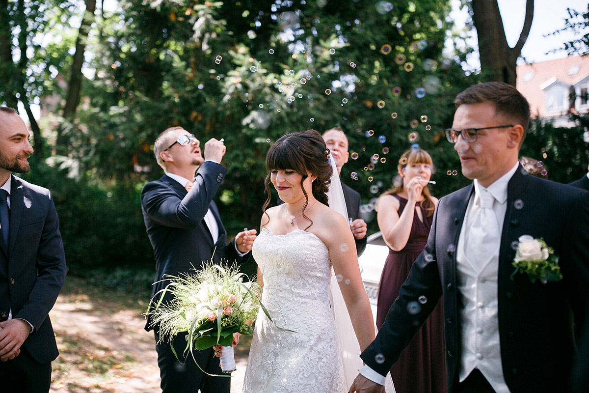 Hochzeitsfoto Auszug Brautpaar nach Trauung Dorfkirche Rudow - Gartenhochzeit Berlin Hochzeitsfotograf © www.hochzeitslicht.de