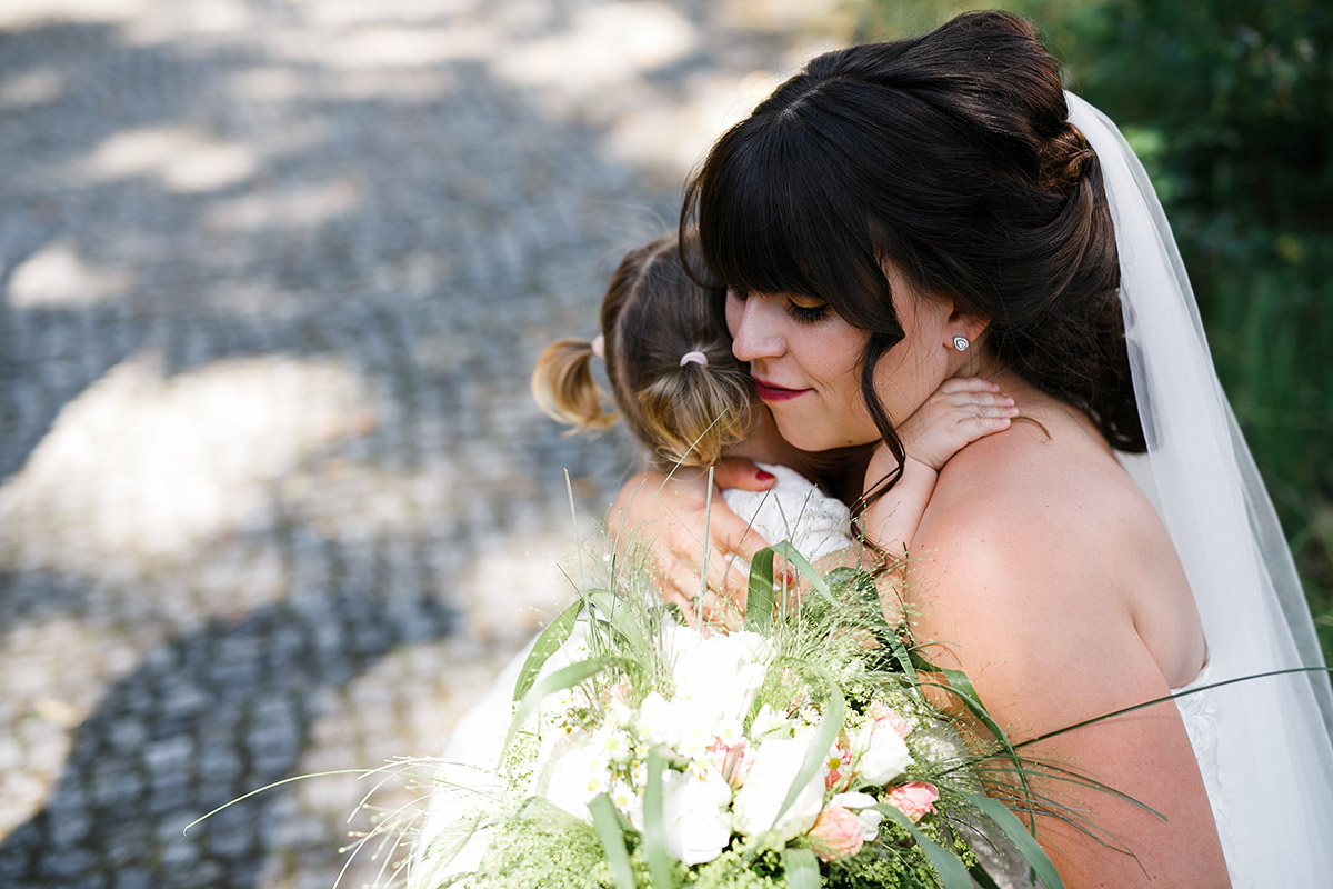 Braut umarmt Tochter - Gartenhochzeit Berlin Hochzeitsfotograf © www.hochzeitslicht.de