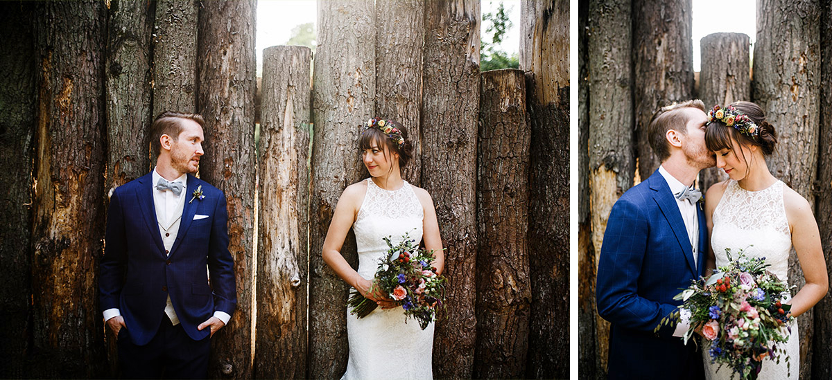 modernes Hochzeitsfoto von Brautpaar vor Holzstämmen bei Sommerhochzeit - Hochzeitsvilla Zehlendorf Berlin Hochzeitsfotograf © www.hochzeitslicht.de