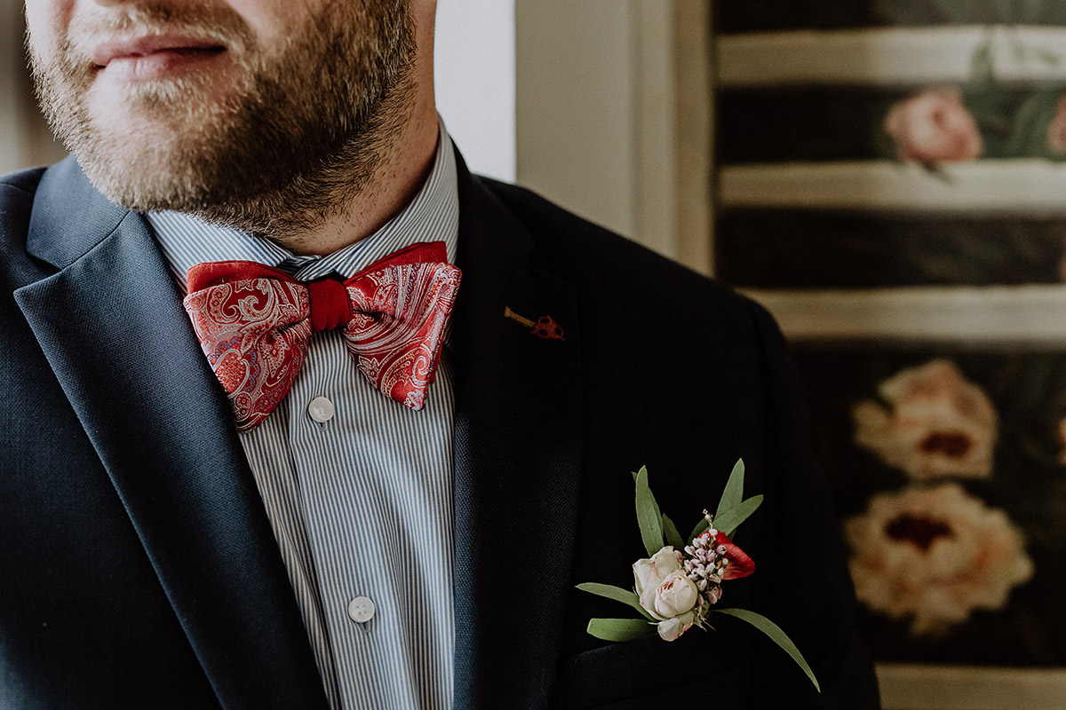 Hochzeitsportrait Bräutigam mit roter Paisley Fliege und gestreiftem Hemd bei deutsch-französischer Hochzeit im Standesamt Mitte - Ermelerhaus Berlin Hochzeitsfotograf © www.hochzeitslicht.de