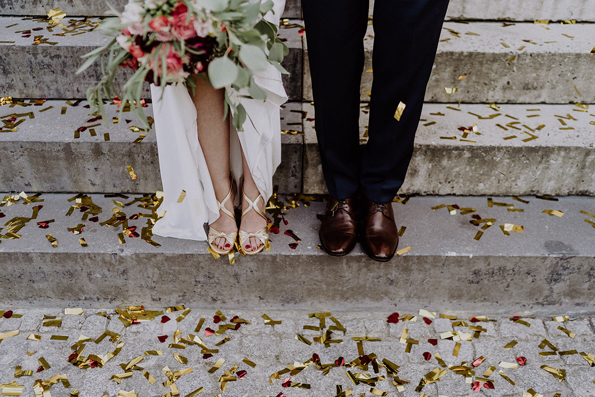 modernes Brautpaarfoto von Beinen Brautpaar mit goldenen Schuhen Braut und braunen Lederschuhen Bräutigam nach intimer Trauung Standesamt Mitte - Ermelerhaus Berlin Hochzeitsfotograf © www.hochzeitslicht.de