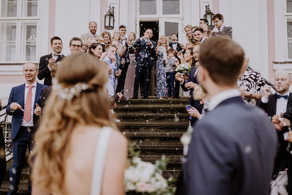 Gäste feiern Brautpaar mit Seifenblasen Hochzeit - Schloss Friedrichsfelde Hochzeitsfotograf © www.hochzeitslicht.de