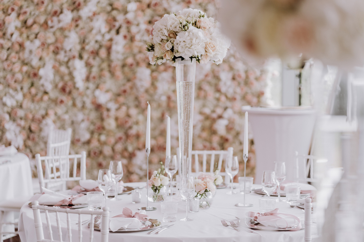 Hochzeitssaal in Eventlocation des Alice Rooftop & Garden mit weiß rosa Hochzeitsdekoration und runden Hochzeitstischen