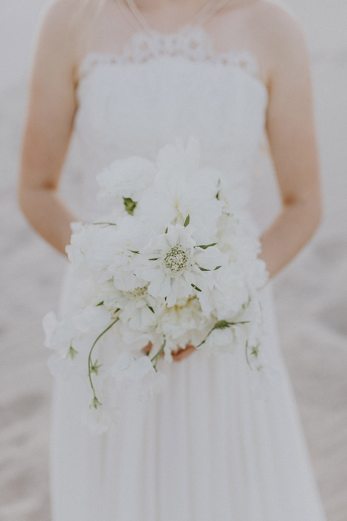 Brautstrauß aus weißen Blumen aus Braut Fotoshooting zur Bridal Fashion Inspiration mit schlichtem langen schulterfreiem Brautkleid im Elfenlook mit tiefem Rücken und grober Spitze oben - Hochzeitsfotograf Berlin Preise © www.hochzeitslicht.de