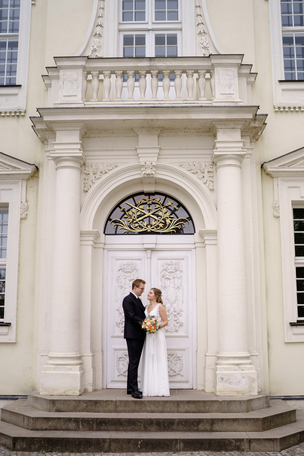 Idee Hochzeitsfoto Schlosshochzeit Schloss Köpenick; Braut in bodenlangem schulterfreien Brautkleid mit Spitzenoberteil und Bräutigam in schwarzem Dreiteiler Hochzeitsanzug - Standesamt Köpenick Hochzeitsfotograf © www.hochzeitslicht.de