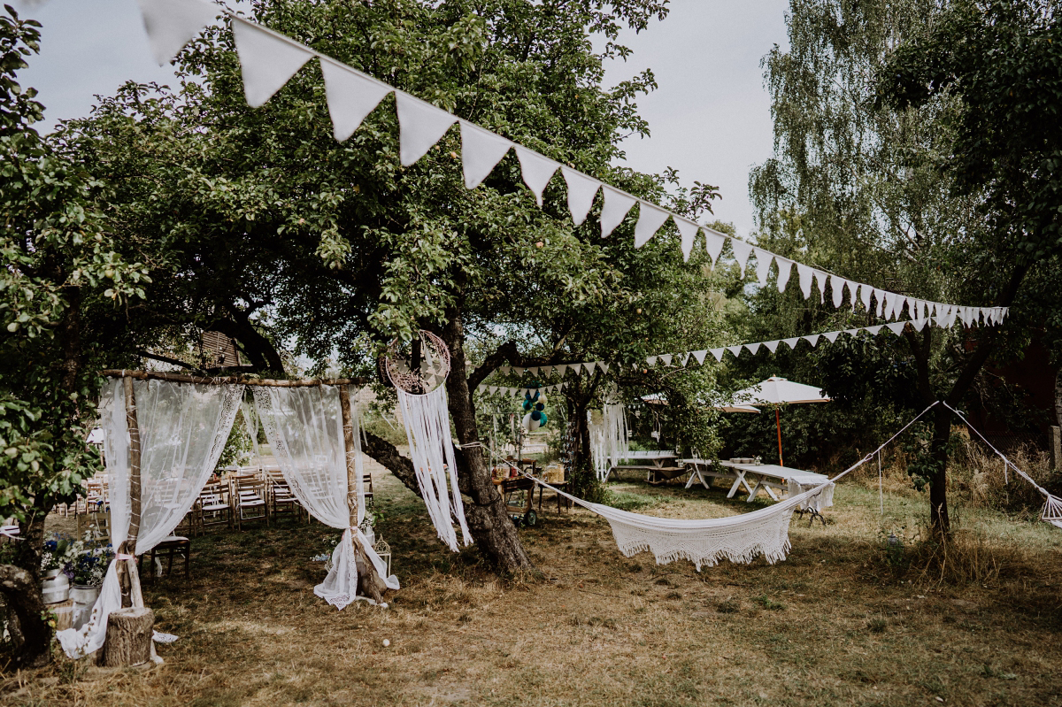 Wimpelgirlanden, Spitzengardinen und Hängematten für vintage Hochzeit - Boho-Scheunenhochzeit in Brandenburg im Schmetterlingsgarten mit Hochzeitsfotografin aus Berlin © www.hochzeitslicht.de