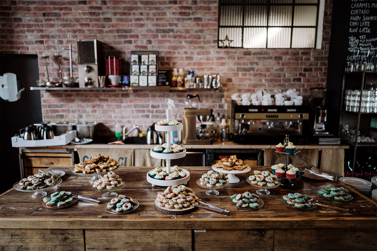 Hochzeitsfoto modern Kuchenbuffet Donuts Cupcakes - urbane Hochzeitsfotos im Restaurant Sonnendeck Hochzeitslocation am Wasser Hochzeitsfotograf Berlin © www.hochzeitslicht.de