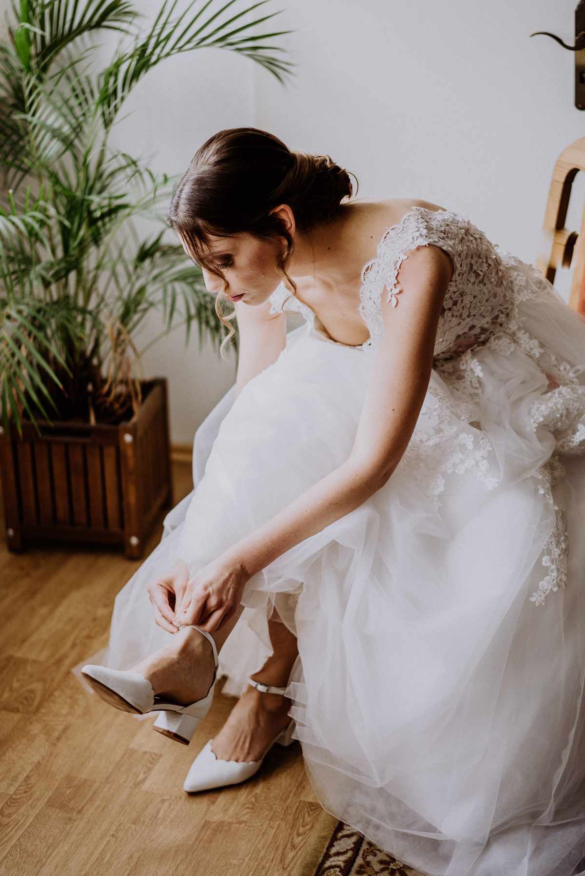 Braut mit Hochzeitskleid aus Spitze und Tüll beim Brautschuhe Anziehen; Dutt Frisur natürliches Make up; beauty real bride - Scheunenhochzeit in Brandenburg - freie Trauung Kulturscheune Thyrow von Hochzeitsfotograf Berlin © www.hochzeitslicht.de #hochzeitslicht