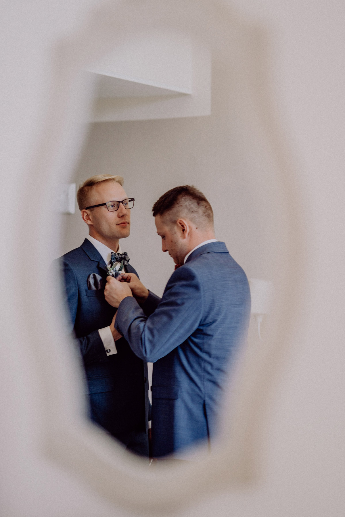 Bräutigam im Sommer in blauem Anzug mit Fliege für Strandhochzeit, maritime Hochzeitsfeier, Hochzeit am Meer; Hochzeitsfoto Idee Hochzeitsmoment Trauzeuge steckt Hochzeitsblumen an #hochzeitslicht Toskana Hochzeitsfotos und Hochzeitsfilm © Destination-Hochzeitsfotograf www.hochzeitslicht.de