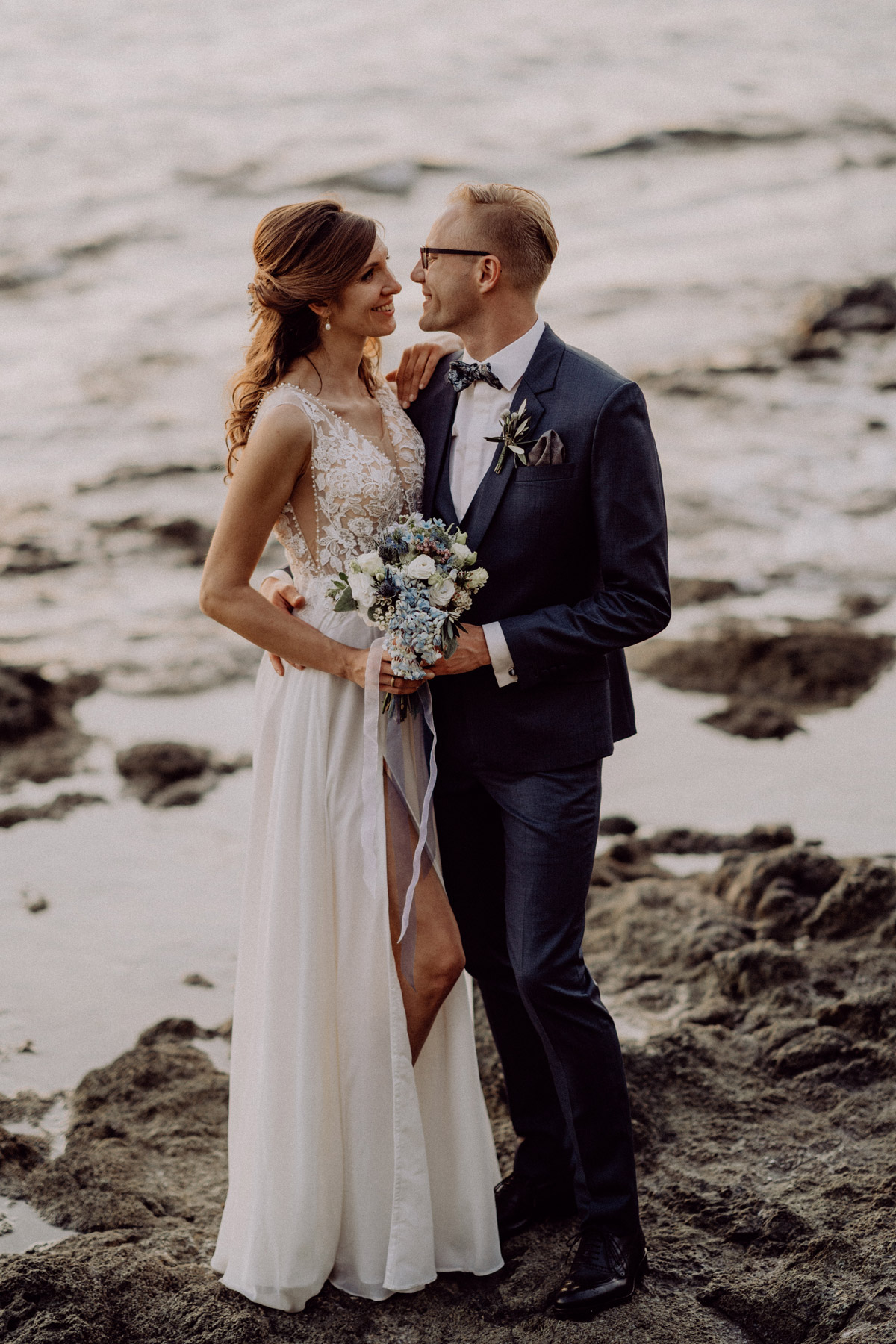 Brautpaarshooting Natur am Meer, natürliche Hochzeitsfotos, elegante Brautpaarbilder , Brautstrauß hellblau mit Hortensien und Rosen, Hochzeitskleid mit Spitze, blauer Anzug Bräutigam, Italien Hochzeit mit Hochzeitplanerin aus Berlin #hochzeitslicht Toskana Hochzeitsfotos und Hochzeitsfilm Destination-Hochzeitsfotograf © www.hochzeitslicht.de #strandhochzeit #hochzeitspaar