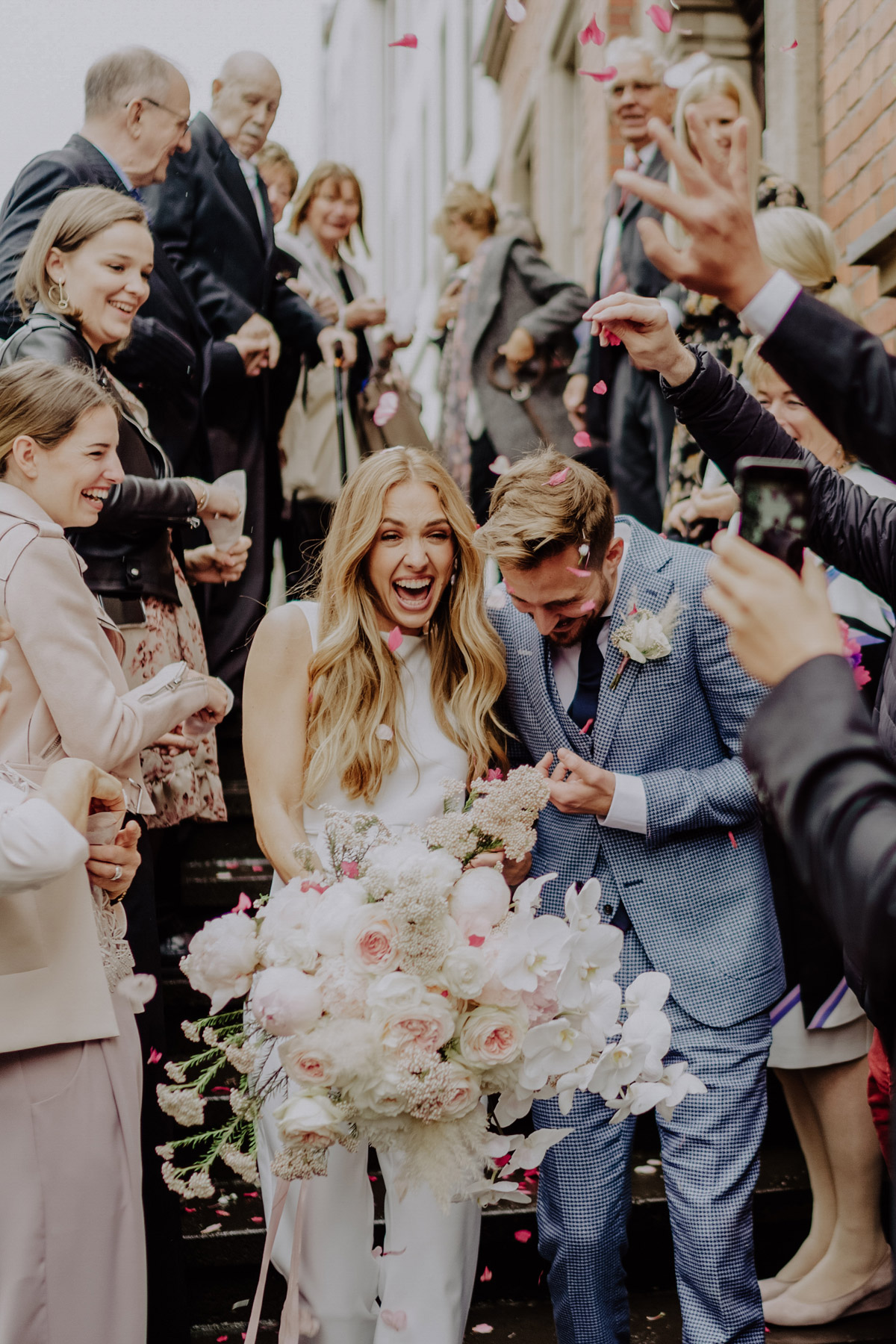 Standesamt Hochzeit Foto Ideen Gäste werfen Blütenblätter auf Hochzeitspar; frisch verheiratetes glückliches Ehepaar bei standesamtlicher Hochzeit mit Regen von Hochzeitsfotografin Berlin © www.hochzeitslicht.de #hochzeitslicht