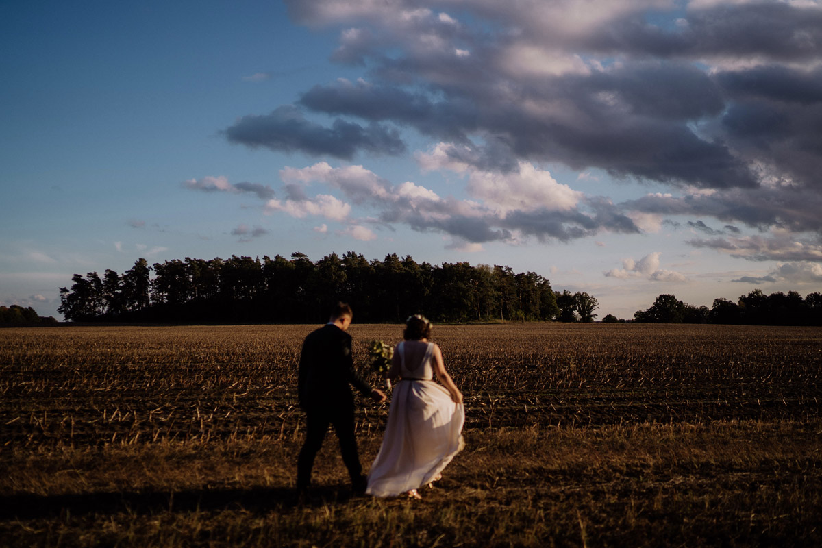 Idee Hochzeitsfoto Brautpaar kleiner im Bild Feld Landhochzeit bewölkt dunkel - Standesamt Corona Hochzeit in Brandenburg mit Hochzeitsfilm von Hochzeitsvideograf Berlin in Bekemühle in Dannenwalde © www.hochzeitslicht.de #hochzeitslicht