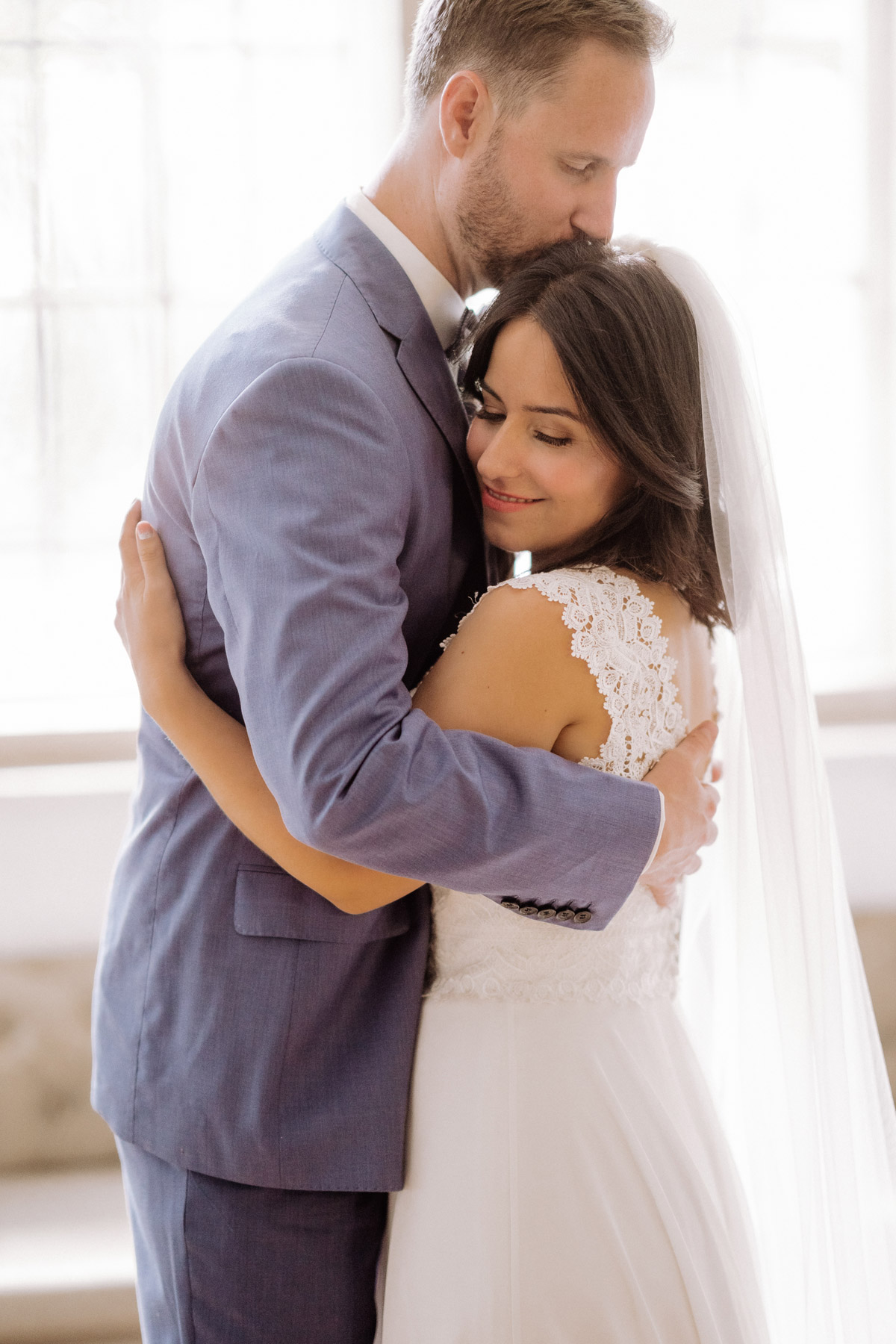 First Look Hochzeitsmoment: Hochzeitsfoto von der Umarmung Braut und Bräutigam vor einem Fenster für schönes weiches Licht auf Corona Hochzeit im von Greifswald von Hochzeitsfotograf und Hochzeitsvideograf Berlin © www.hochzeitslicht.de #hochzeitslicht