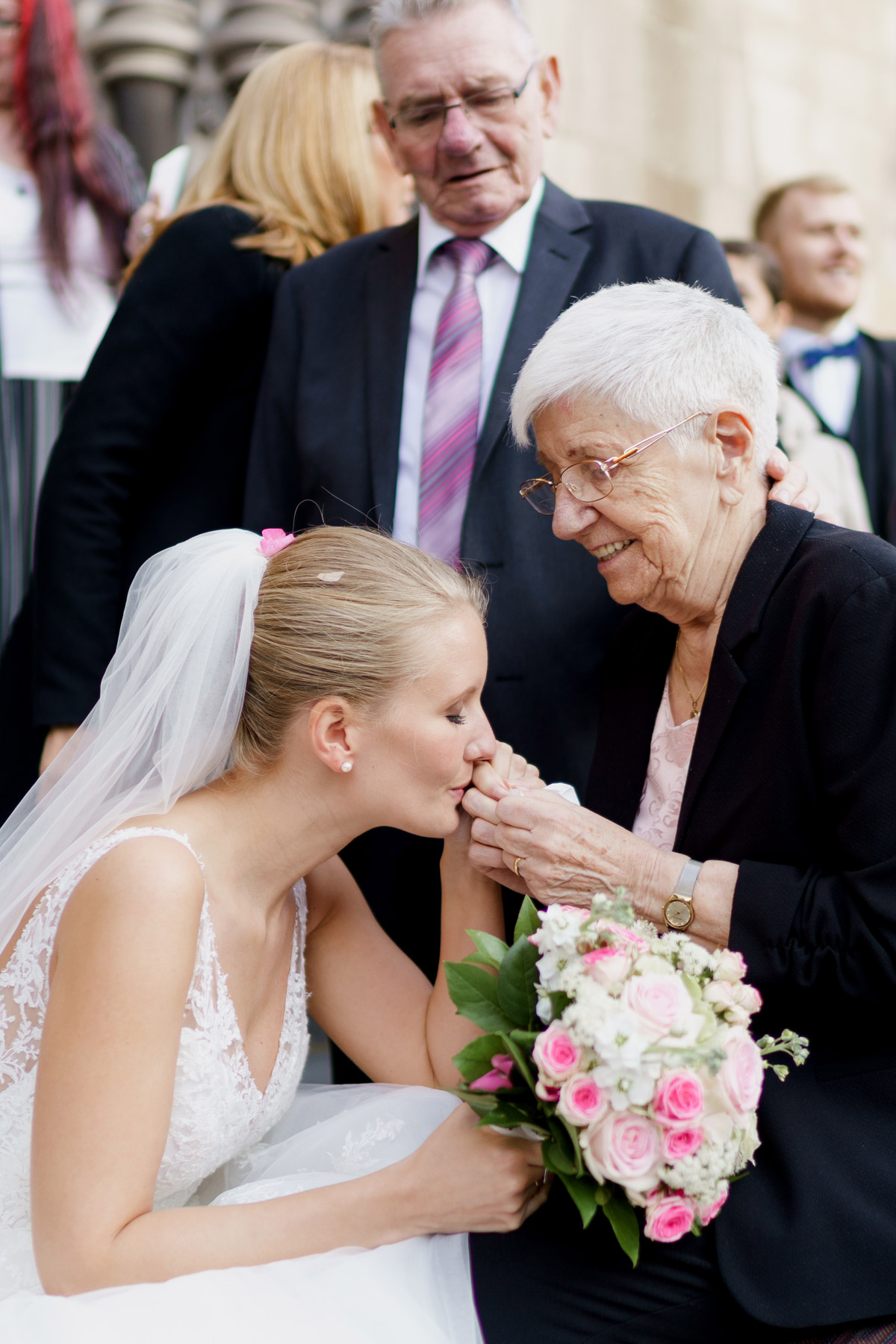 Emotionaler Hochzeitsmoment nach kirchlicher Trauung: In dieser Hochzeitsreportage in Berlin in der St. Johannes Basilika küsst die Braut bei der Gratulation die Hand ihrer Oma. Anschließend wurde in der Hochzeitslocation im Titanic Hotel am Gendarmenmarkt gefeiert. © www.hochzeitslicht.de #hochzeitslicht #beautyrealbride