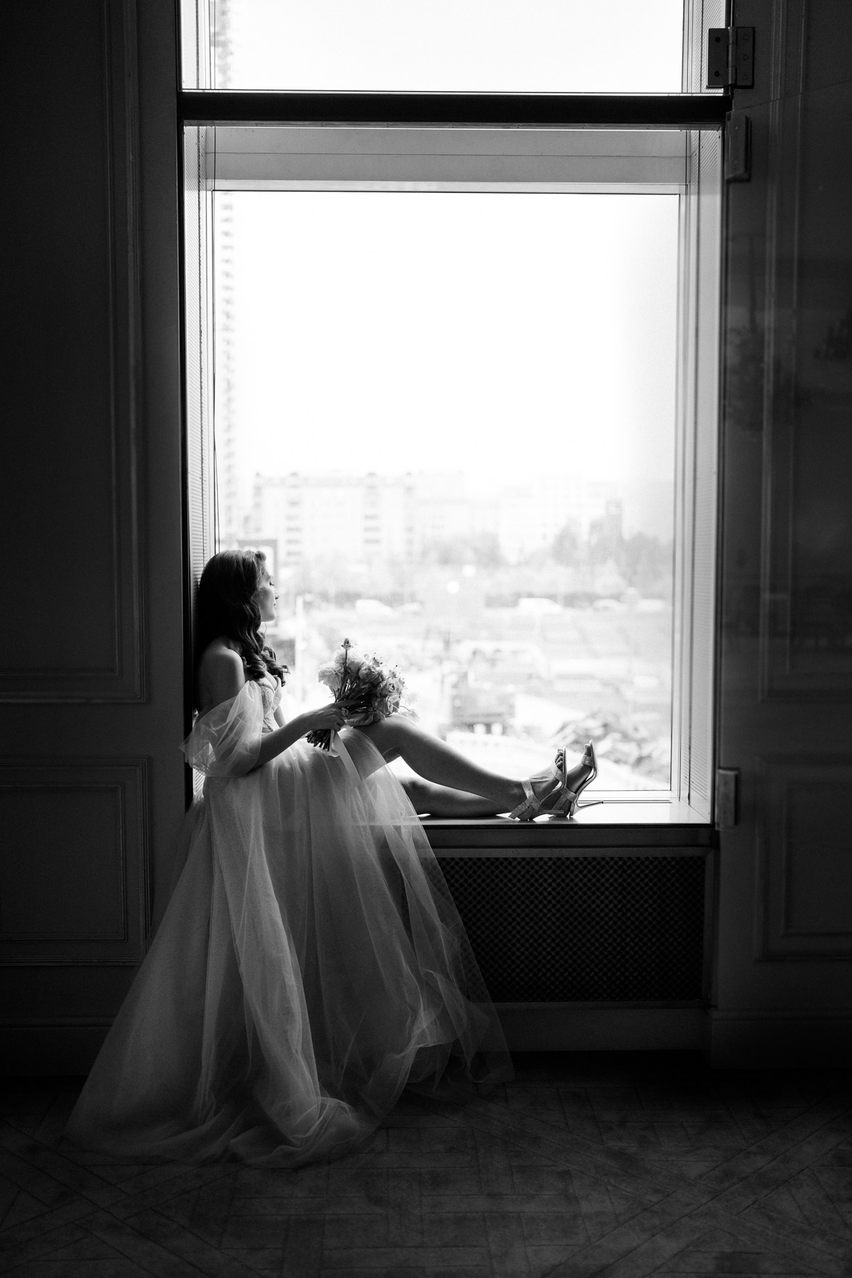 auf Hotel Adlon Kempinski Hochzeit in Berlin schaut Braut im Bridal Fashion Shooting aus dem Fenster - Fine Art schwarzweiß Hochzeitsfoto © www.hochzeitslicht.de #hochzeitslicht