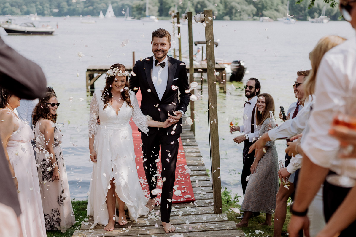 Einzug Brautpaar mit Boot bei Hochzeit am Wasser - Standesamt Gartenhochzeit mit Hochzeitsvideo von Hochzeitsvideografin und Hochzeitsfotografin aus Berlin © www.hochzeitslicht.de #hochzeitslicht