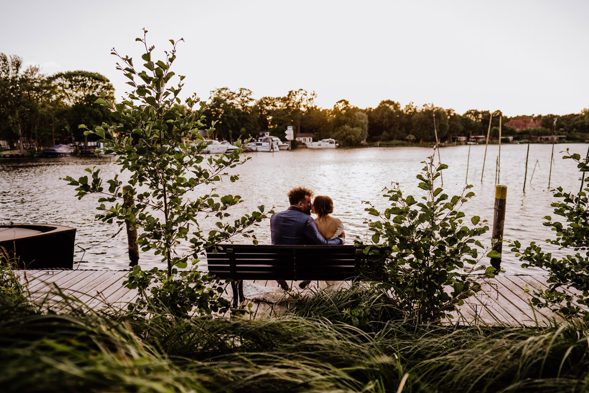 Hochzeitsfotoidee Brautpaar auf Bank am Wasser - Celestial Galaxy Wedding: himmlische Hochzeit mit Mond und Sternen in Farben Blau, Violett und Gold in Hochzeitslocation Potsdam am Wasser Remise am See - mehr im Hochzeitsblog von Hochzeitsfotograf © www.hochzeitslicht.de #hochzeitslicht