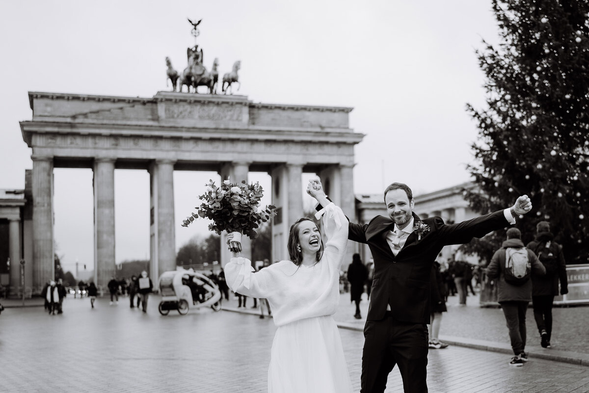 wedding photographer berlin with a happy bridal couple in front of the Brandenburg Gate after their civil wedding
