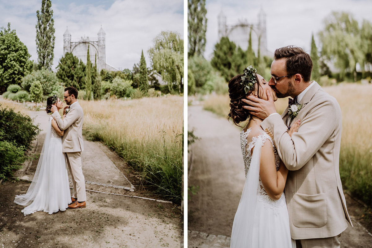 Bräutigam küsst Braut im Park im Botanischen Garten vor Mittelmeerhaus kurz nach der Standesamt Hochzeit