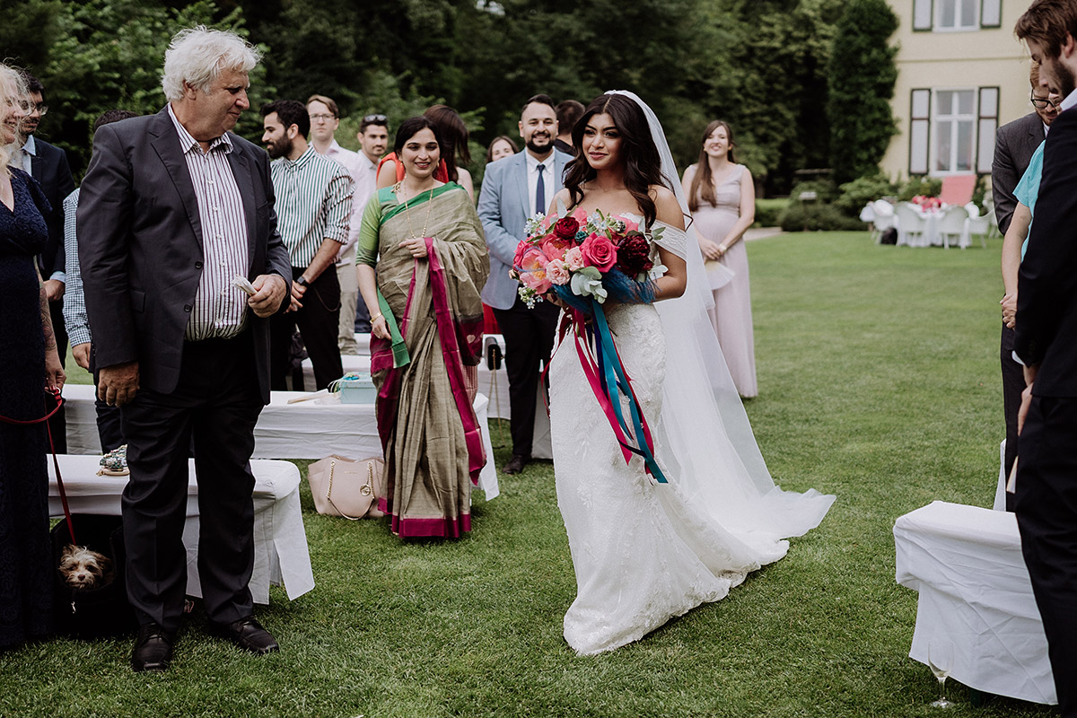 ungestelltes Hochzeitsreportagefoto Braut Einzug freie Trauung - Hochzeitsfotografin aus Berlin auf eleganter Gartenhochzeit in Hochzeitslocation Potsdam am Wasser im Gut Schloss Golm während Corona Pandemie © www.hochzeitslicht.de #hochzeitslicht