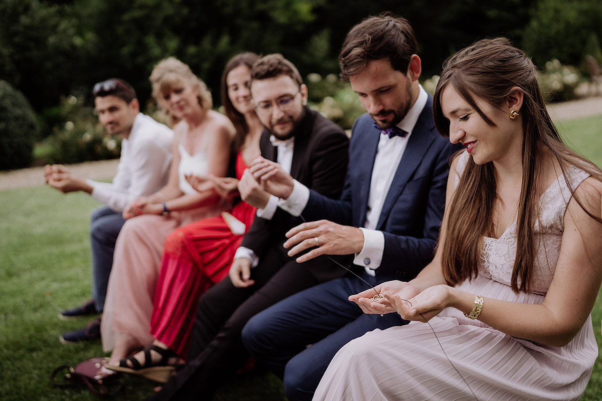 Ritual freie Trauung Ringe an Band - Hochzeitsfotografin aus Berlin auf eleganter Gartenhochzeit in Hochzeitslocation Potsdam am Wasser im Gut Schloss Golm während Corona Pandemie © www.hochzeitslicht.de #hochzeitslicht