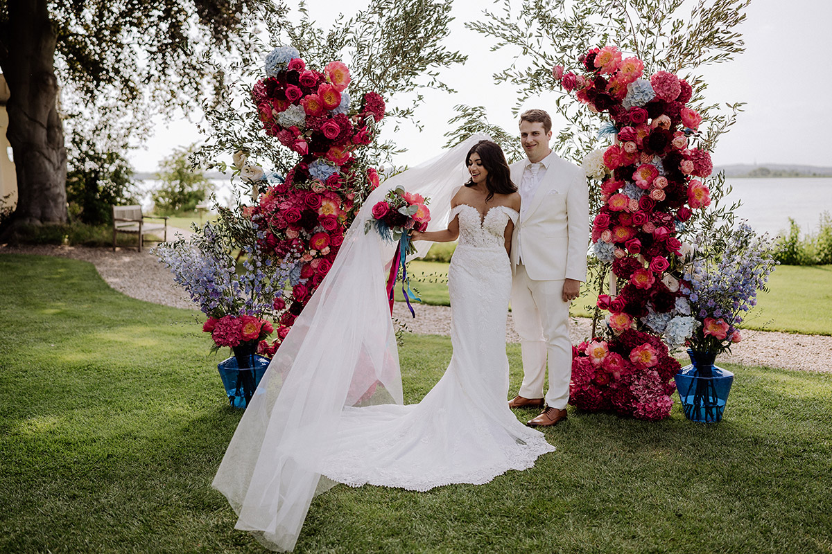 Hochzeitsfoto Hochzeitspaar vor Traubogen am Wasser - Hochzeitsfotografin aus Berlin auf eleganter Gartenhochzeit in Hochzeitslocation Potsdam am Wasser im Gut Schloss Golm während Corona Pandemie © www.hochzeitslicht.de #hochzeitslicht