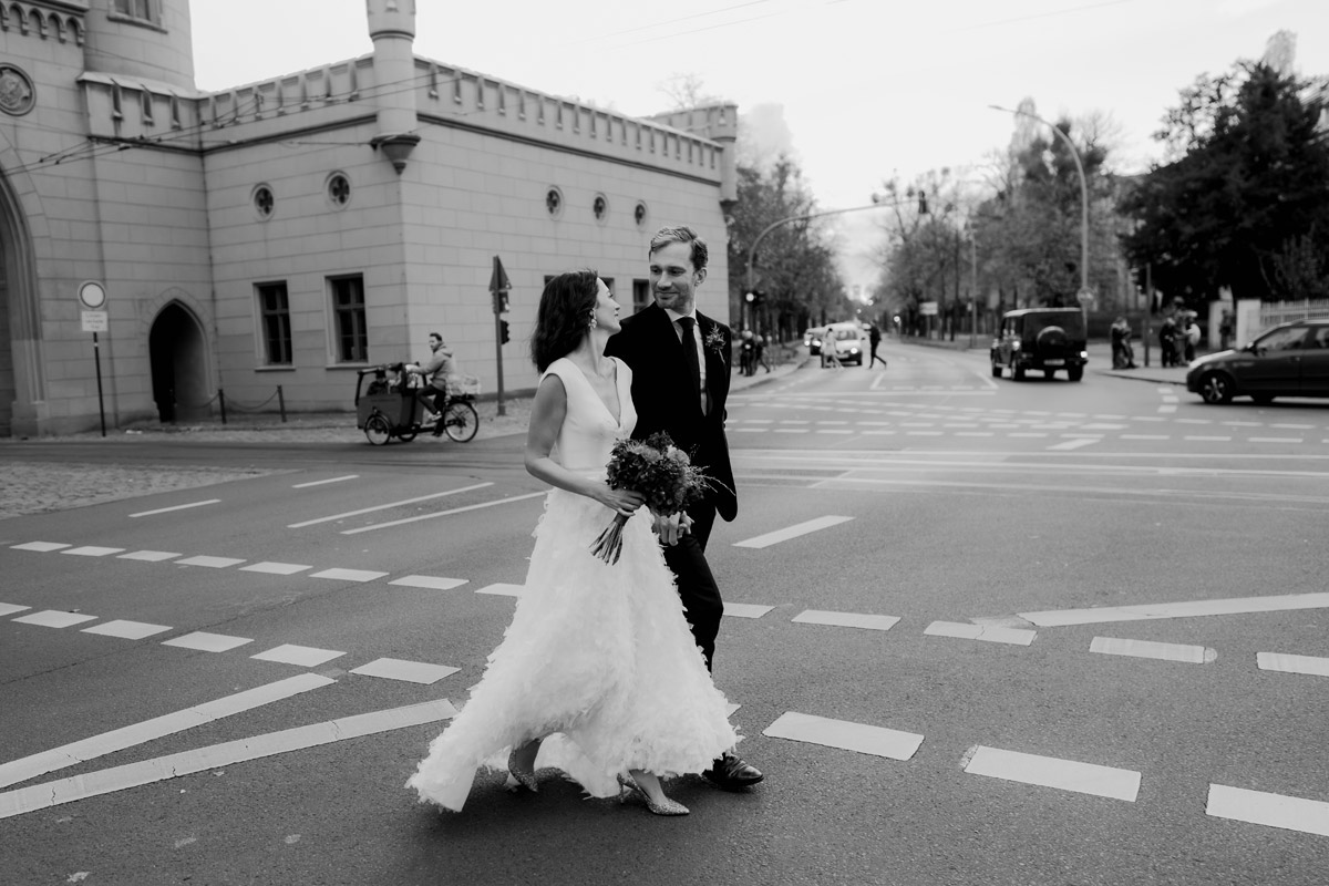 Hochzeitsfotografin Potsdam hält Paar beim Überqueren der Straße fest