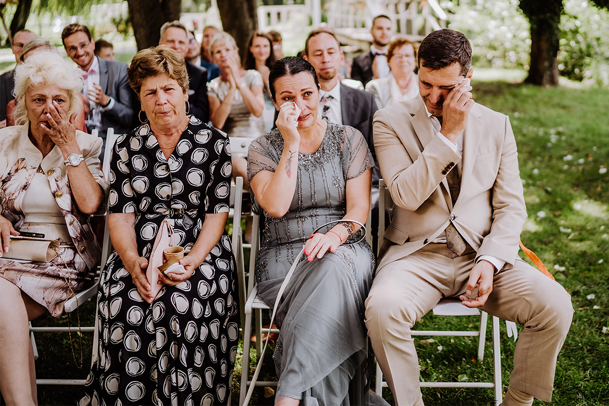 Hochzeitsgäste weinen bei Hochzeit im Garten festgehalten von Hochzeitsfotografin aus Berlin