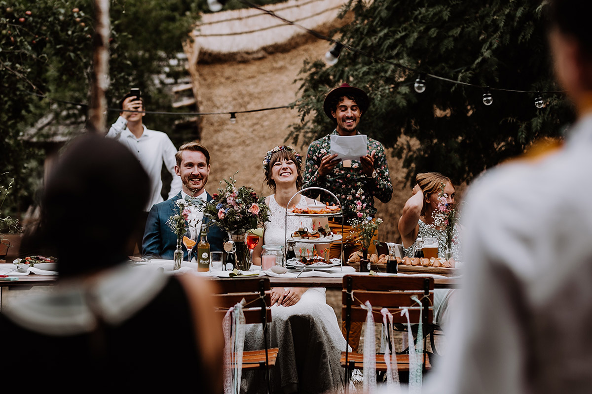 Hochzeitspaar lacht am Tisch auf Gartenhochzeit im Museumsdorf Düppel