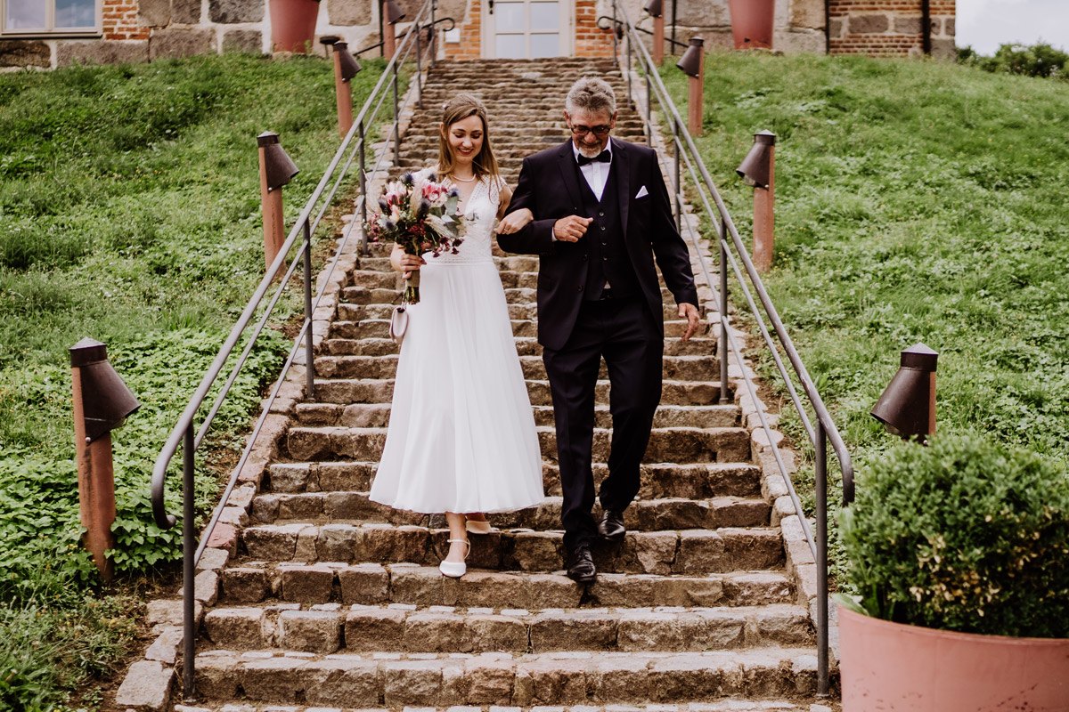 Braut mit Vater steigt die Treppen vom Schloss und Gut Ulrichshusen hinab