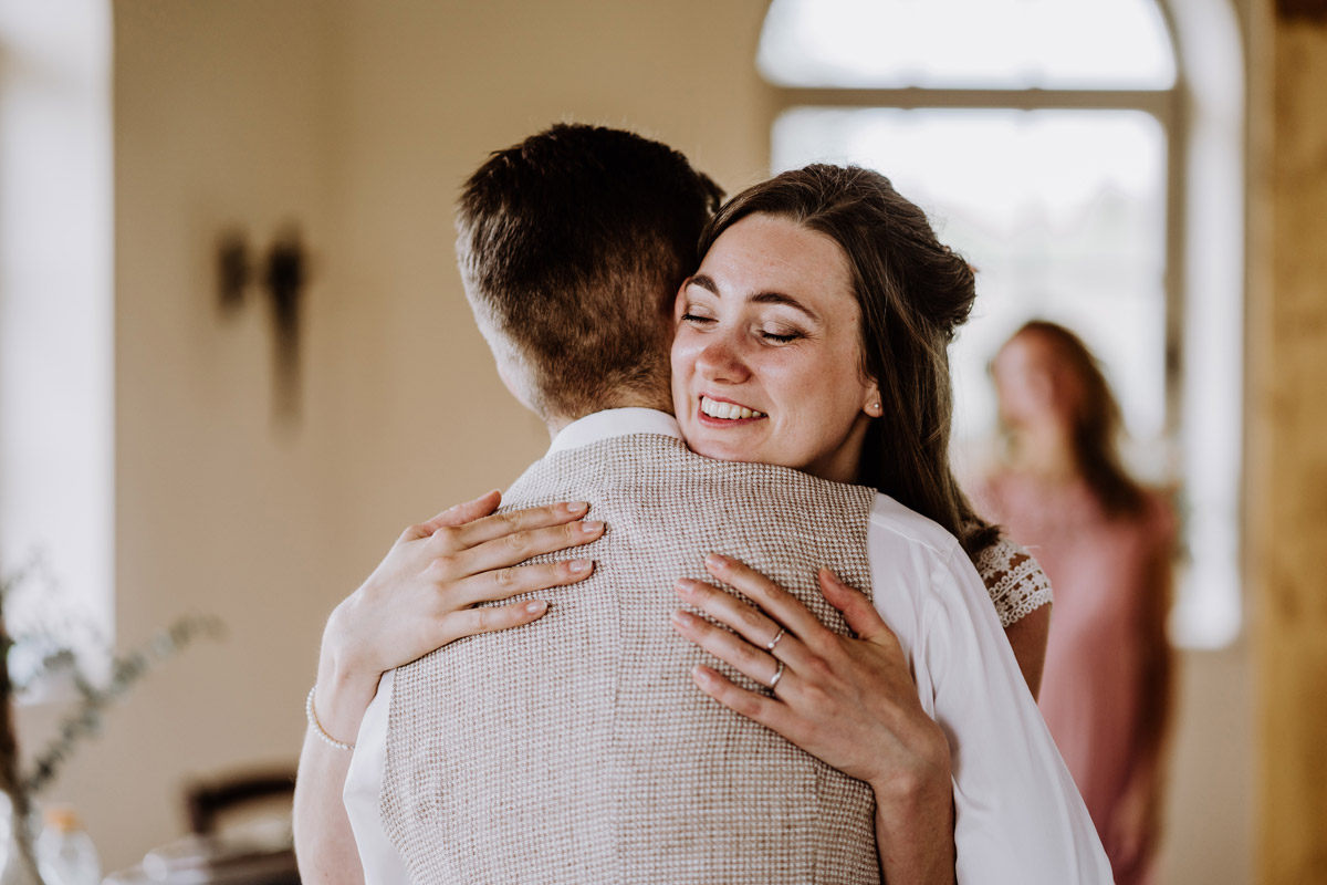 Braut umarmt Bräutigam bei freier Trauung