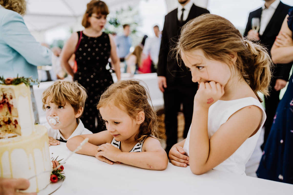 witziger Hochzeitsmoment Kinder liebäugeln mit der Hochzeitstorte