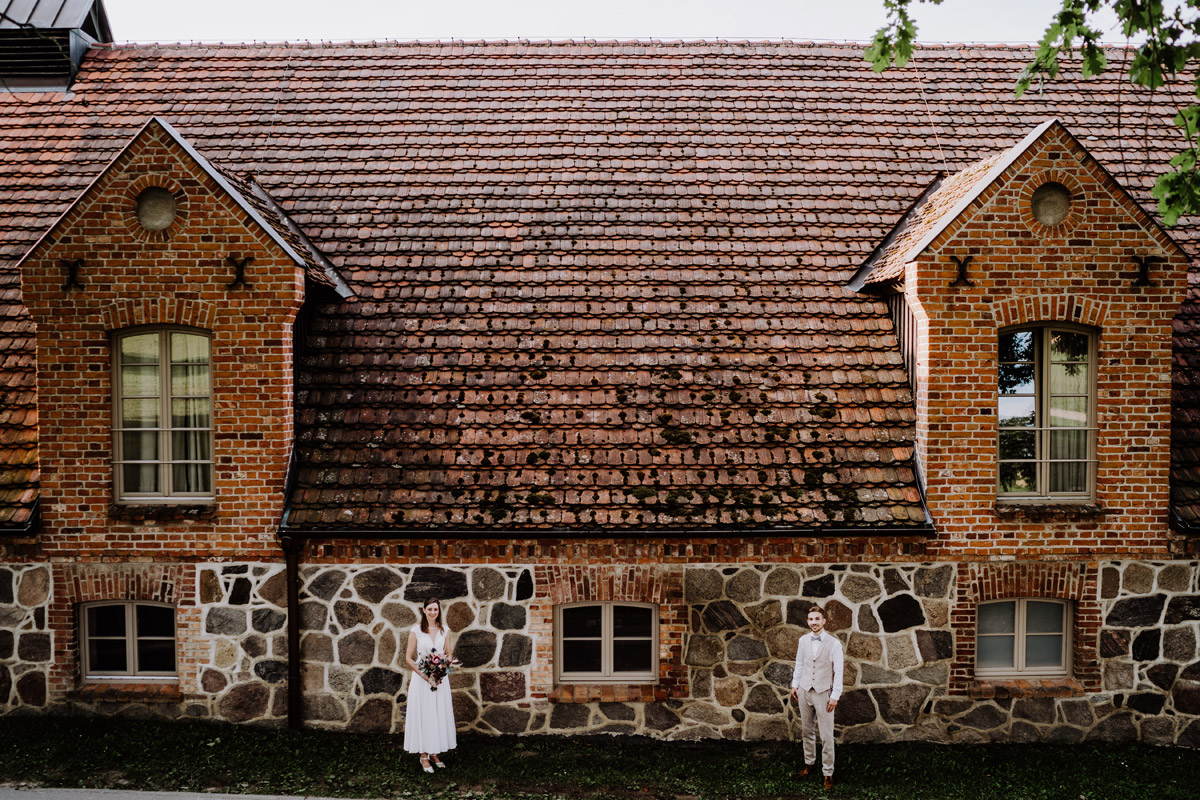 kreatives und außergewöhnliches Hochzeitpaar Foto vor Feldsteinhaus in Mecklenburg-Vorpommern