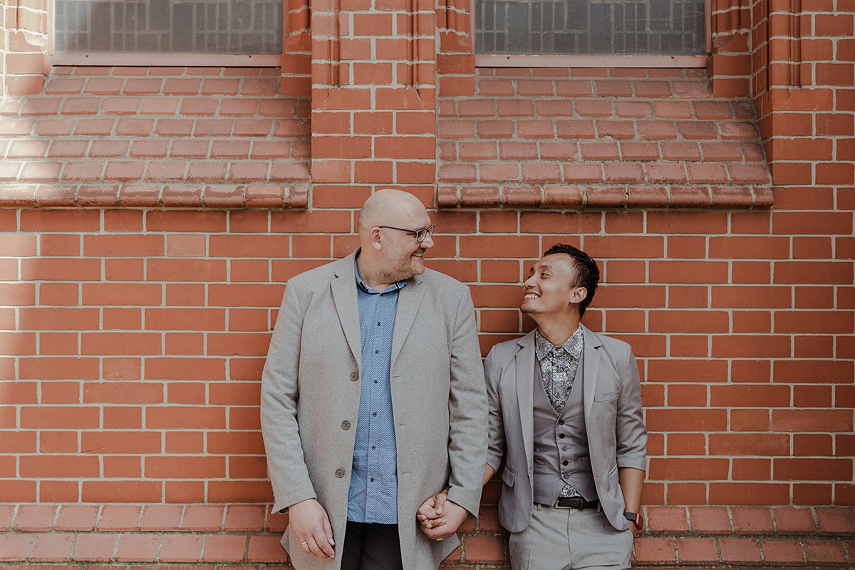 Schwule Standesamt Hochzeit von Hochzeitsfotografin Berlin - zwei Bräutigame schauen sich glücklich und verliebt nach dem standesamtlichen Heiraten an