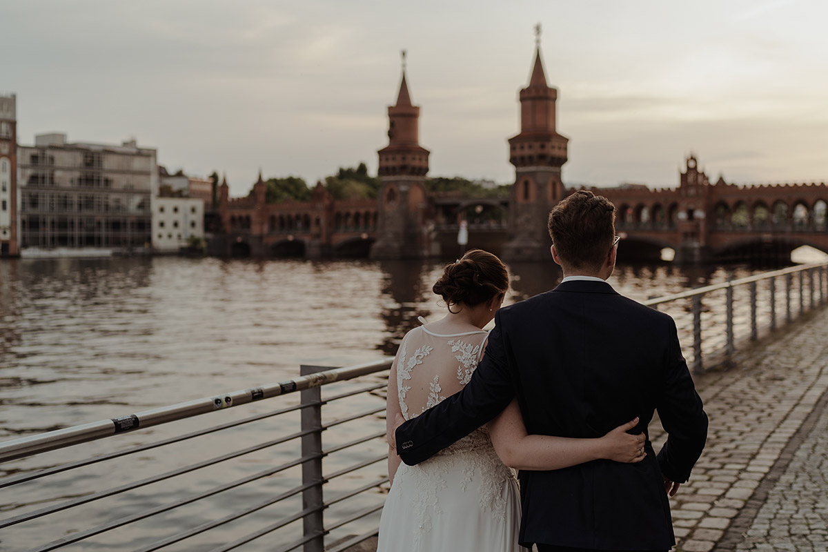 Spreespeicher Hochzeitsfotograf zeigt Brautpaar von hinten an Oberbaumbrücke