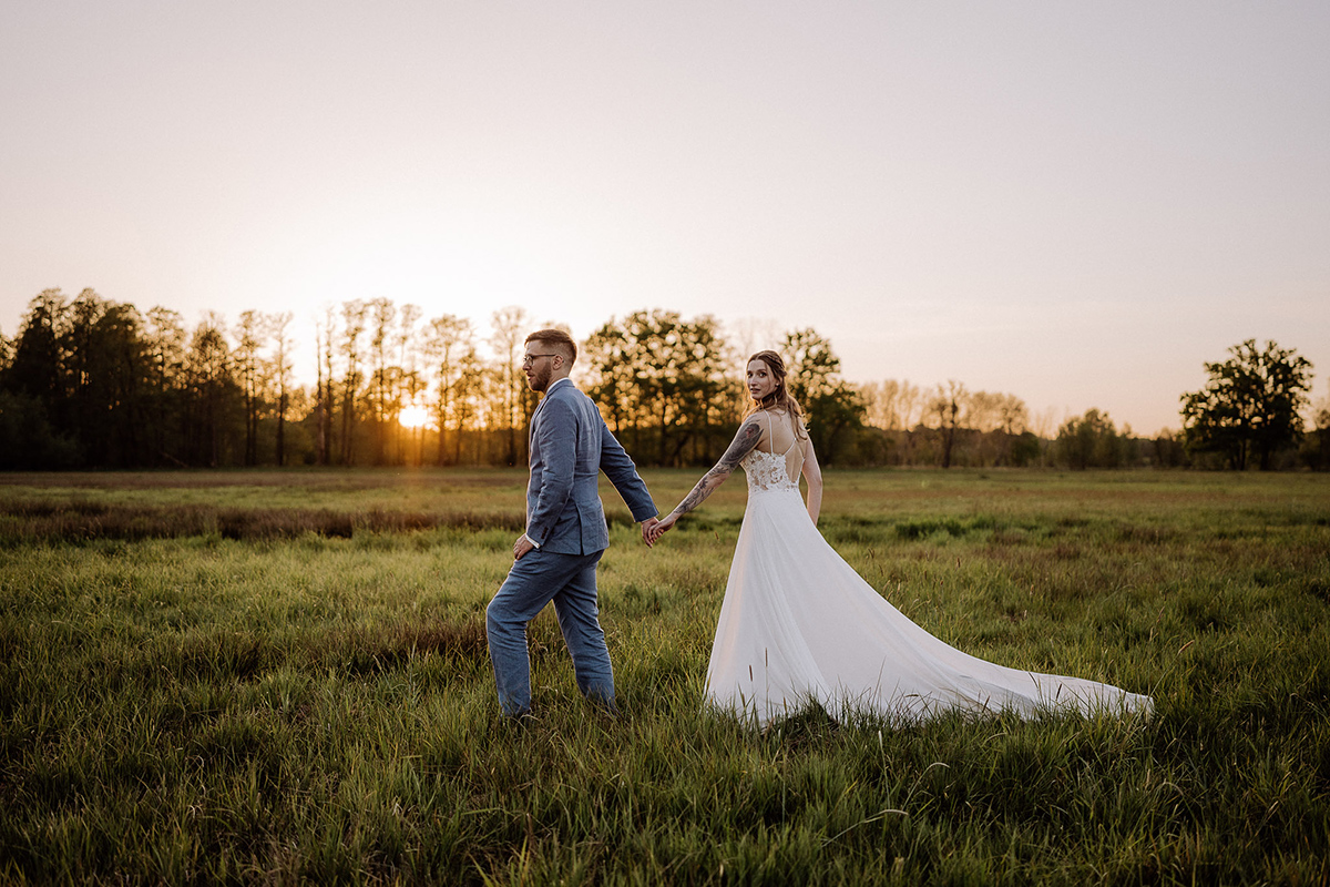 Standesamt Hochzeitsfotografin aus Berlin hält im Spreewald das Paar auf Wiese im Gehen fest