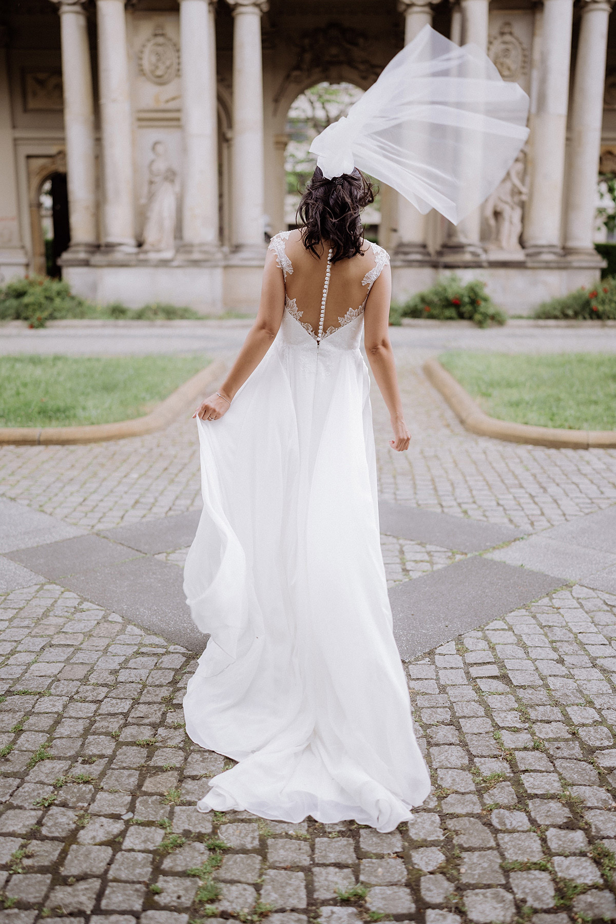 Braut im Standesamt Hochzeitskleid Berlin steht von hinten im Wind