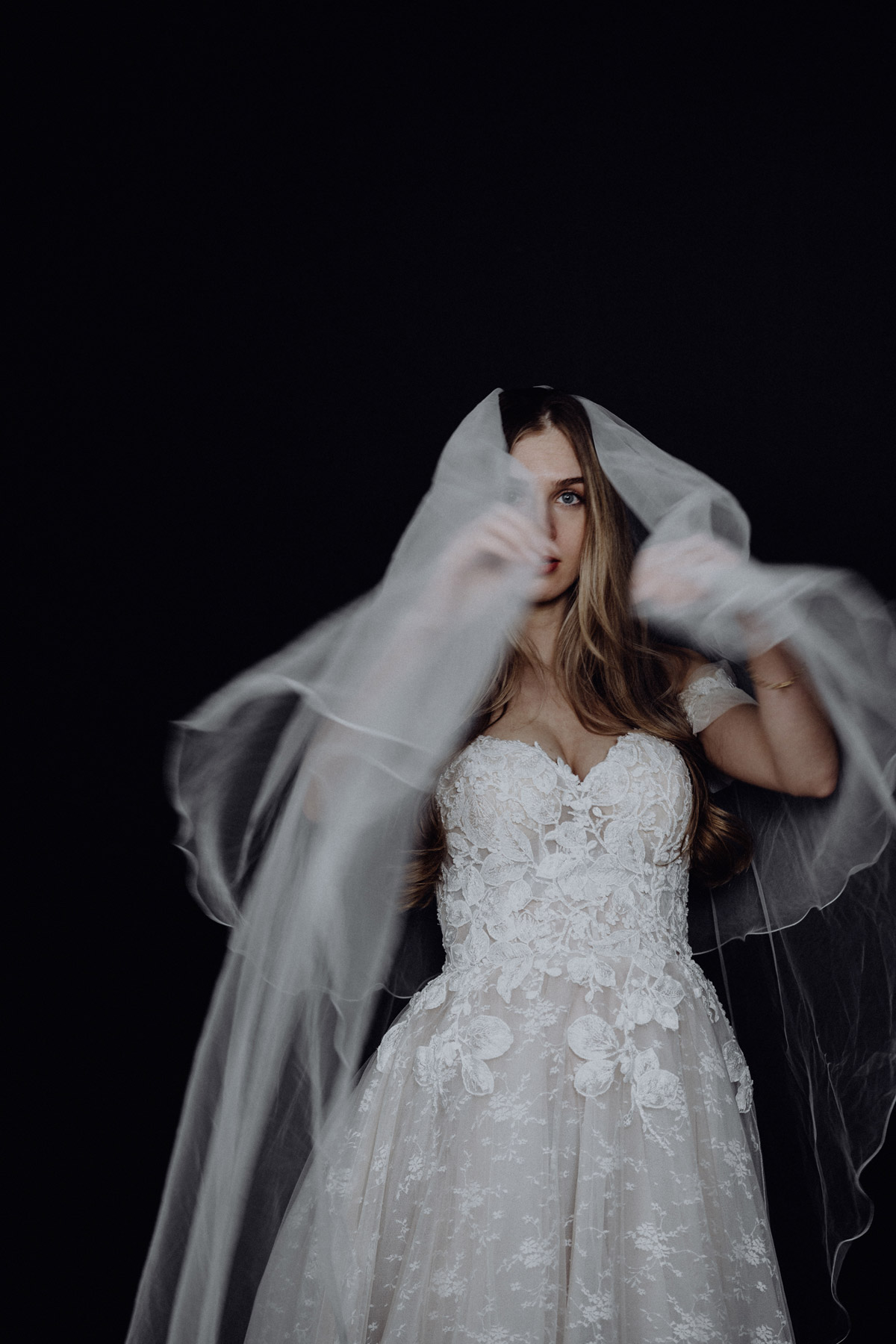 Bridal Portrait Photoshoot: Our Berlin bride is showing a timeless pose. She waves her veil during a wedding photo shoot in the studio. Visit our blog to see more ideas. © www.hochzeitslicht.de #hochzeitslicht