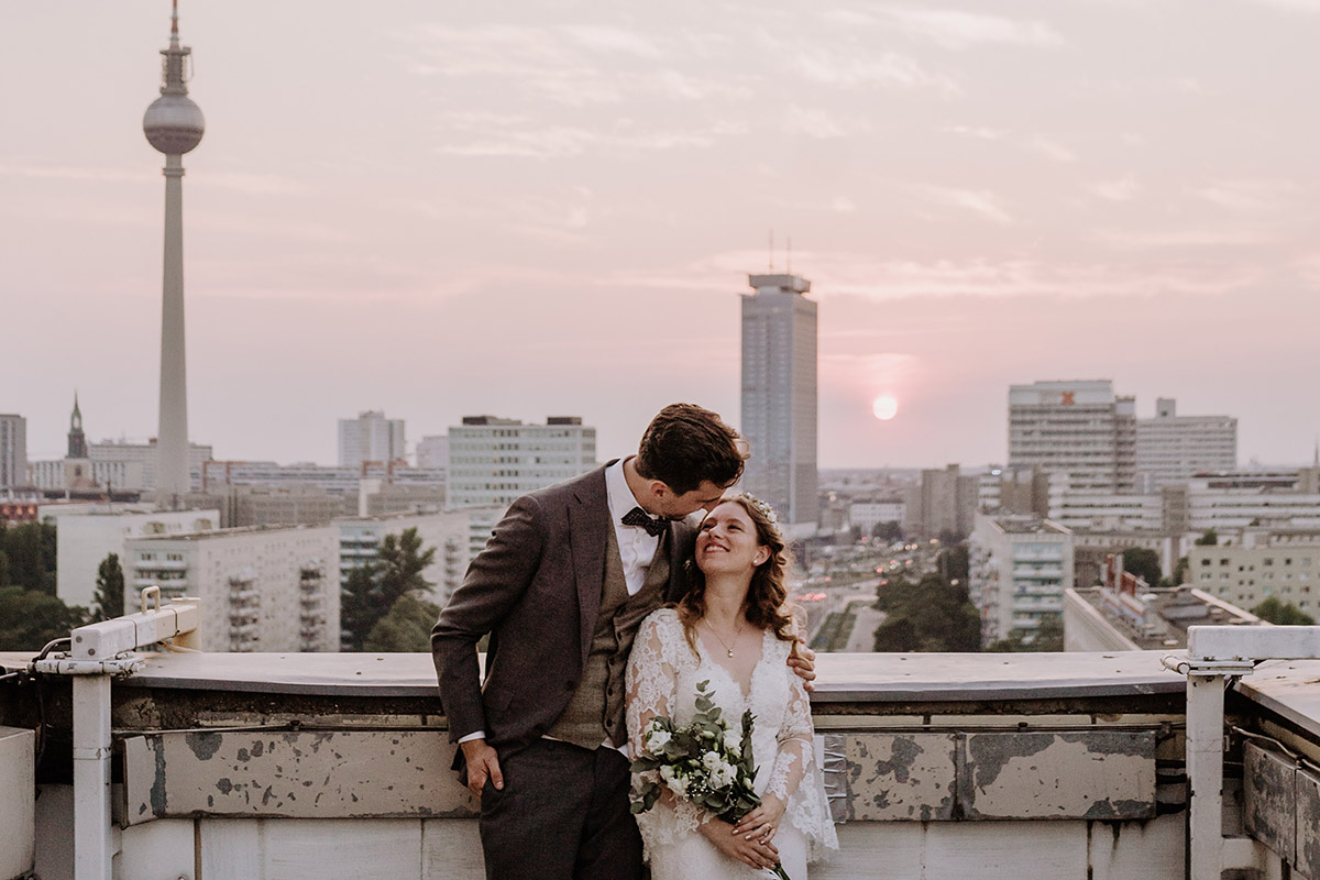 couple at wedding in Berlin is snuggling infront of the skyline with Fernsehturm captured by hochzeitslicht wedding photographer