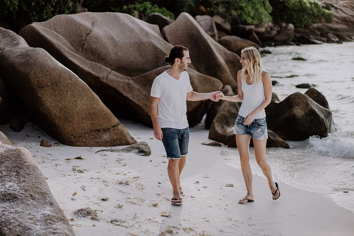 couple moves naturally while Seychelles photo shoot at the beach before destination wedding