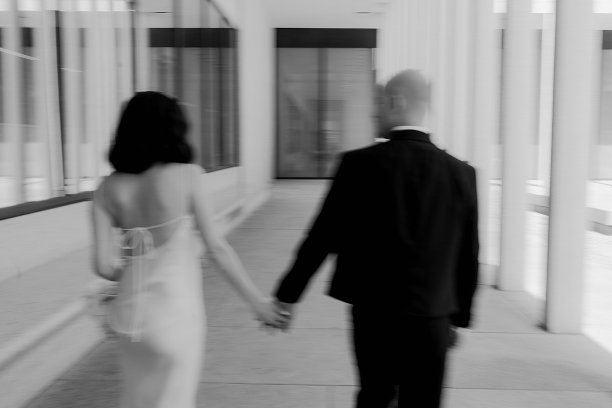 Hochzeitsfotografin fotografiert Paar modern von hinten im Gehen mit Bewegungsunschärfe
