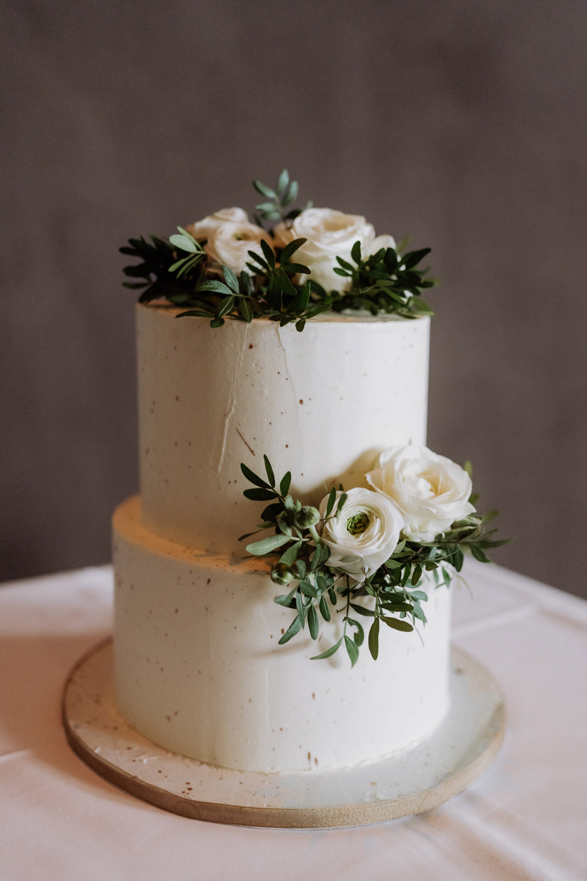 Hochzeitstorte weiß, zweistöckig mit weißen und grünen Blumen und goldenen Spritzern © www.hochzeitslicht.de #hochzeitslicht